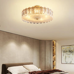 Ceiling light fixture in a bedroom setting with neutral walls and a bed.