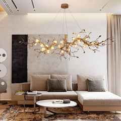 Modern living room with a stylish chandelier, beige sectional sofa, and decorative items.