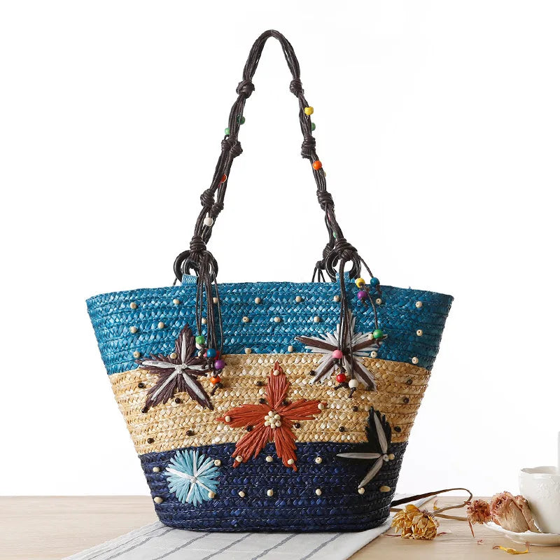 A beautiful bohemian straw tote bag with hand-embroidered starfish and beaded details.