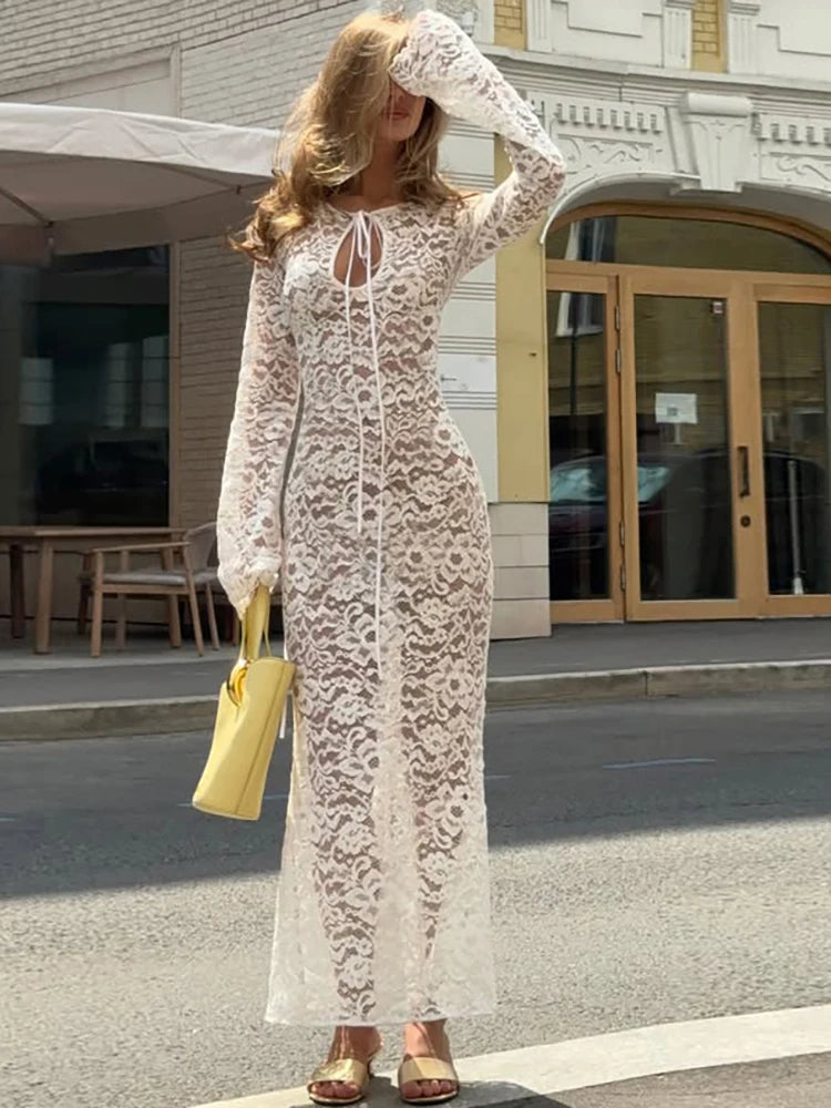 White lace maxi dress with long sleeves and keyhole neckline on a city street