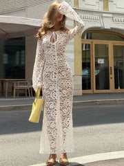White lace maxi dress with long sleeves and keyhole neckline on a city street