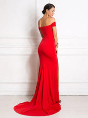 Golden Atelier off-shoulder maxi dress in a solid color with a fitted bodice featuring padded bust detail, a flowing mermaid skirt with a leg split, modeled on a woman in a formal setting. Red 1