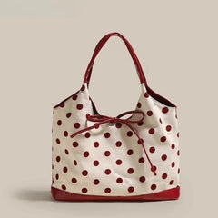 Polka dot handbag with red trim on a beige background
