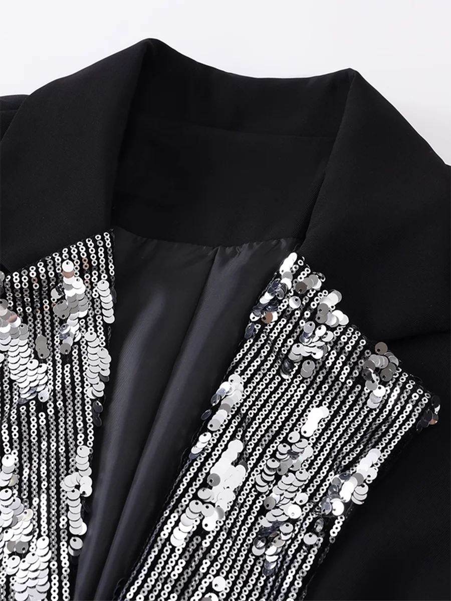 Black garment with silver sequin detailing on a white background