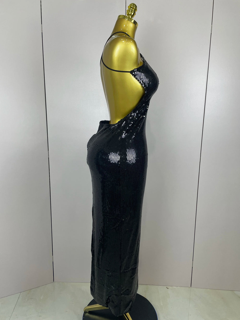 Black sequin dress on a mannequin against a white wall