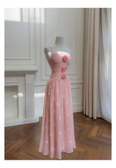 Pink embroidered midi dress with rose embellishments on a mannequin
