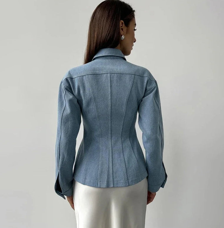 Woman wearing a blue denim jacket against a plain background