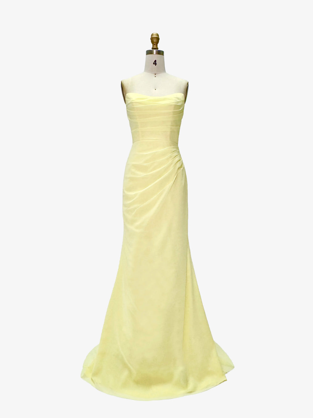 Yellow evening gown on a mannequin against a white background