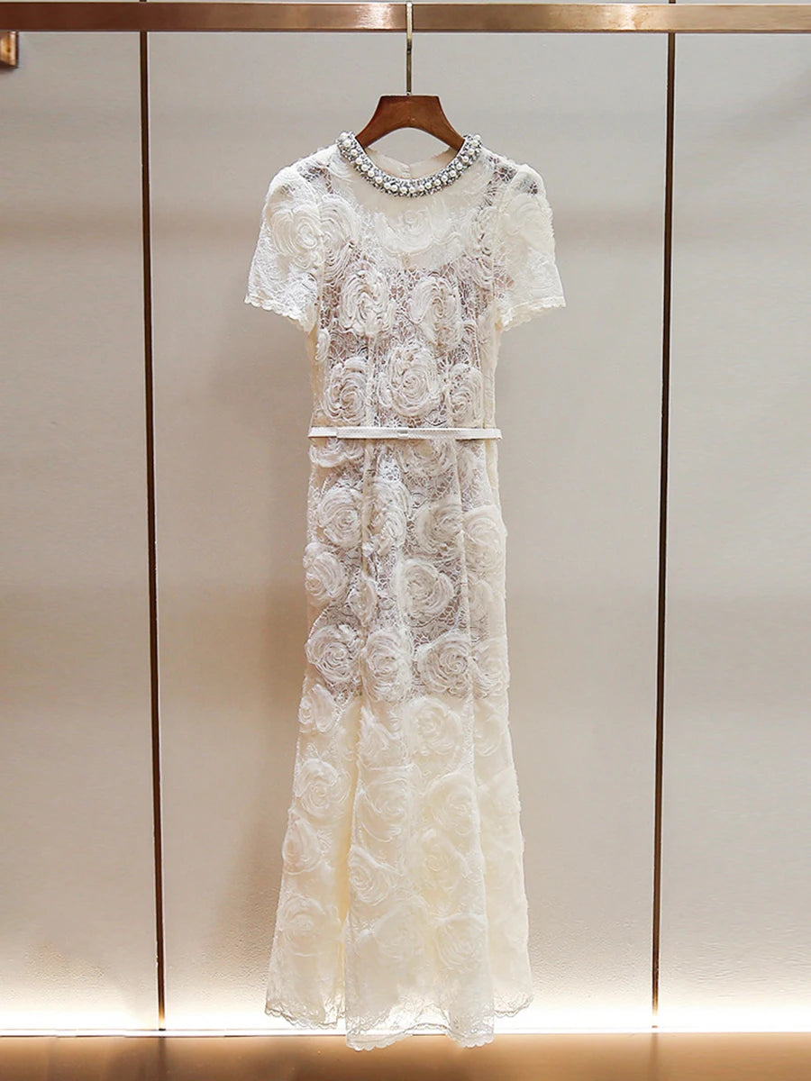 White lace dress with embellishments on a wooden hanger against a neutral background