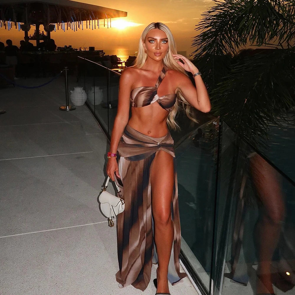 Abstract print two-piece swimwear with a matching high-slit skirt.