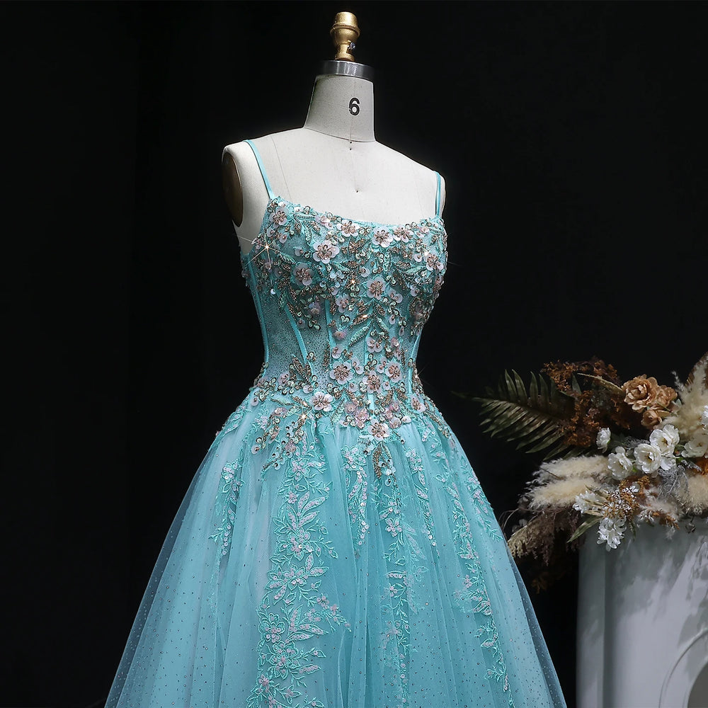 Teal evening gown with floral embroidery on a mannequin against a dark background.