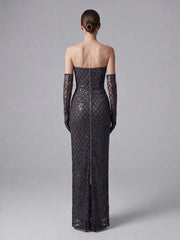 Black strapless evening gown with lace detailing on a gray background