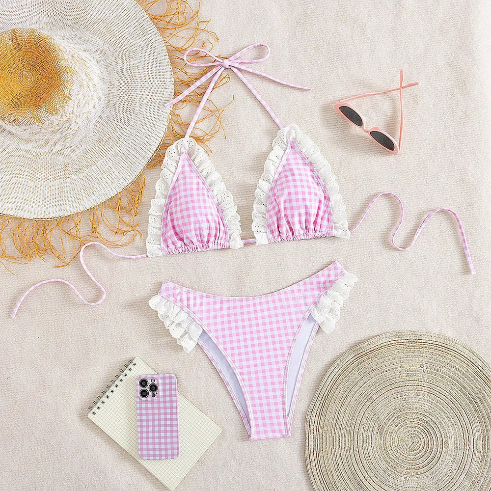 Flat lay of gingham ruffled bikini set with accessories