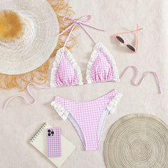 Flat lay of gingham ruffled bikini set with accessories