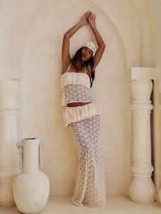 Model posing in a ruched satin camisole and sheer lace maxi skirt set.