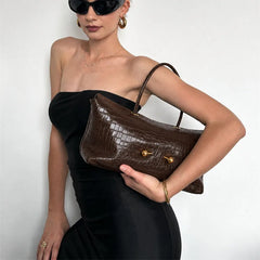 Crocodile embossed leather shoulder bag worn by a model