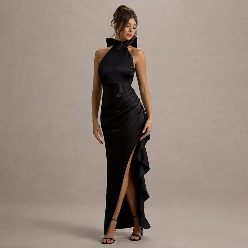 Woman wearing a black evening gown with a high slit on a beige background