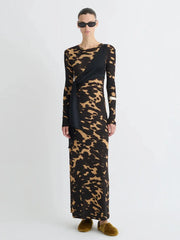 Model wearing a long black dress with a gold animal print pattern