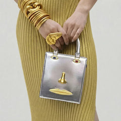 Silver sculptural face structured tote bag with top handle.