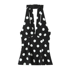Black sleeveless top with white polka dot pattern on a white background
