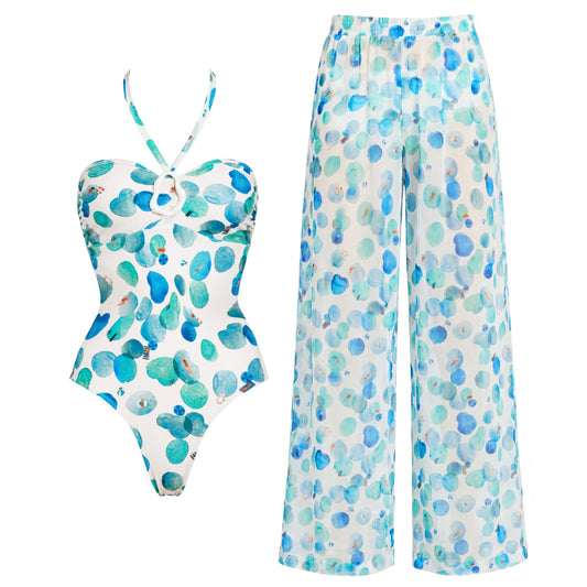 White one-piece swimsuit with abstract blue and green dots and matching wide-leg pants.