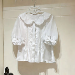 A white sheer puff sleeve blouse displayed on a hanger.