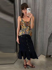 Model wearing a floral print peplum top and denim midi skirt