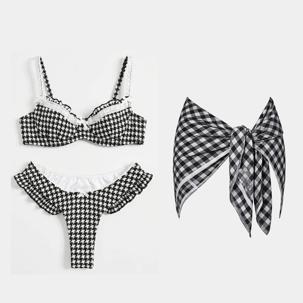 Black and white houndstooth ruffled bikini and skirt set with white trim.