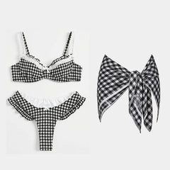 Black and white houndstooth ruffled bikini and skirt set with white trim.