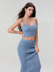 Woman wearing a blue knit two-piece set on a gray background