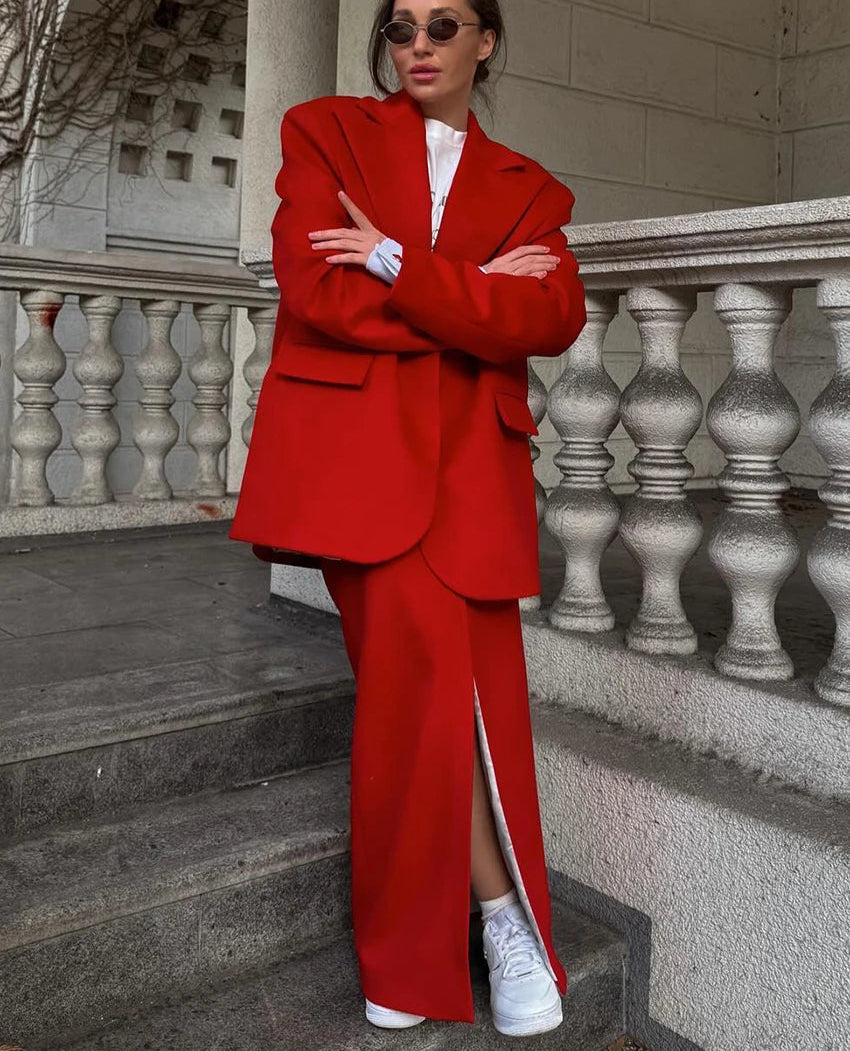 Person wearing a red suit standing on steps with a building in the background