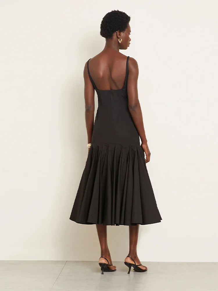 Woman wearing a black dress with a plain background