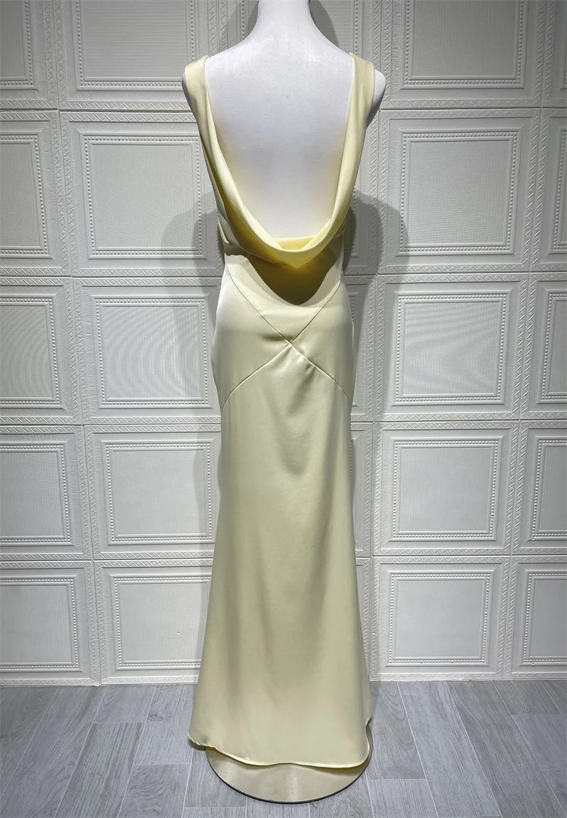 Light green dress on a mannequin against a white paneled wall.