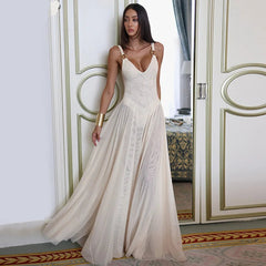 Woman in a white dress standing in an elegant room with decorative walls.