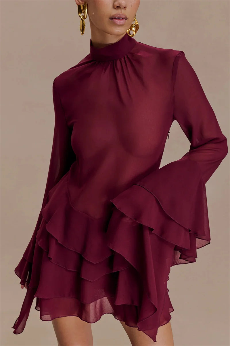 Maroon dress with ruffled layers on a beige background