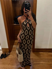 Woman taking a mirror selfie wearing a patterned dress in a room with wooden floor and white wall.