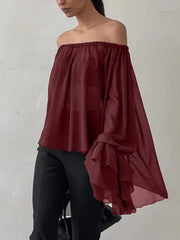 Woman wearing a burgundy off-shoulder top against a white background