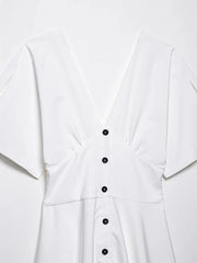 White shirt with black buttons on a light gray background