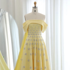 Mannequin  displaying the yellow satin evening gown with cape, showcasing its flattering silhouette and vibrant color. Golden Atelier 3