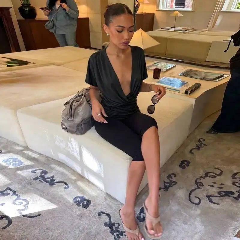 Woman wearing a black V-neck ruched crop top while seated