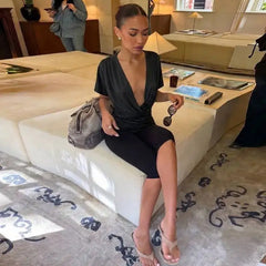 Woman wearing a black V-neck ruched crop top while seated