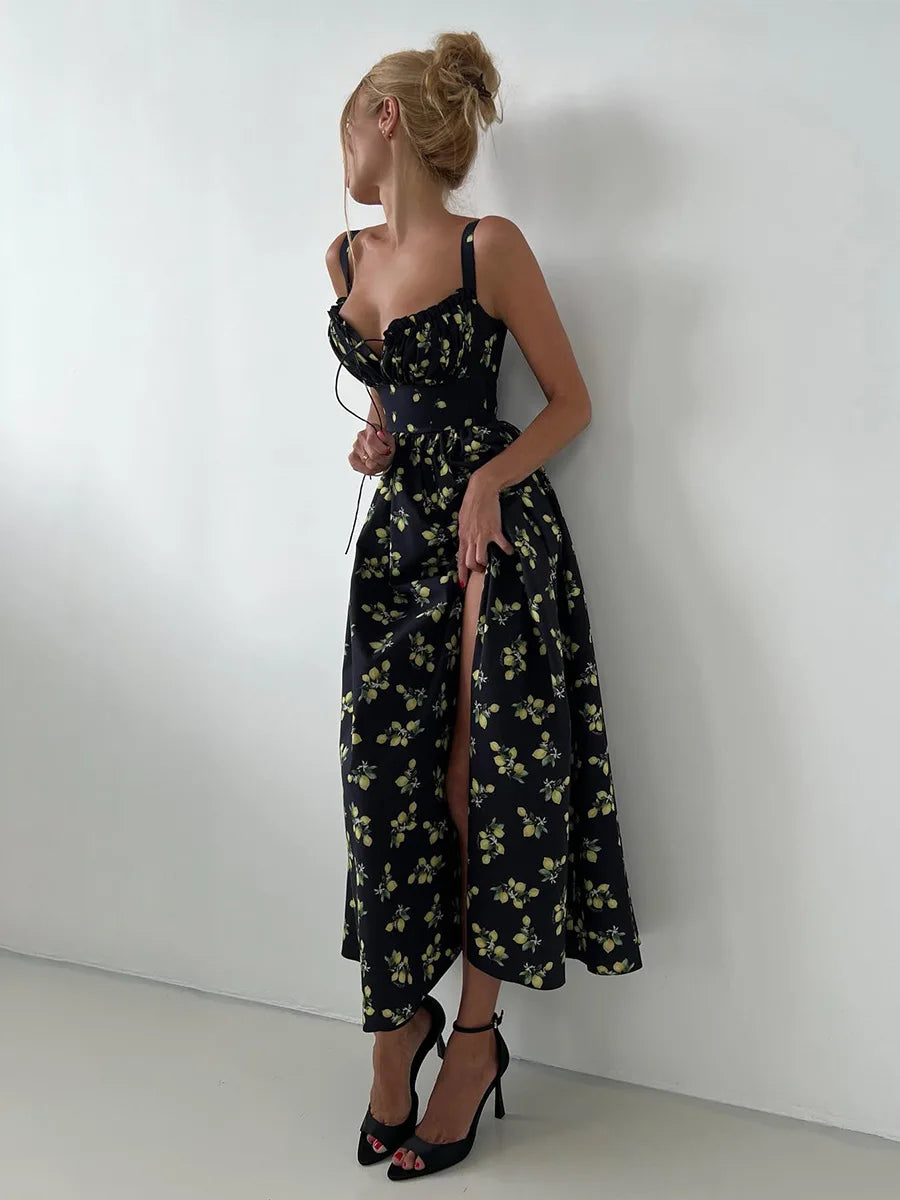Woman wearing a black floral dress against a white wall