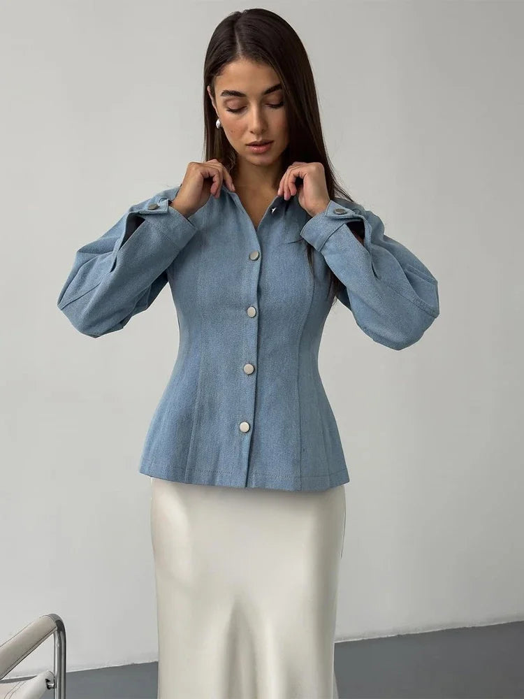 Woman wearing a blue denim blouse against a plain background