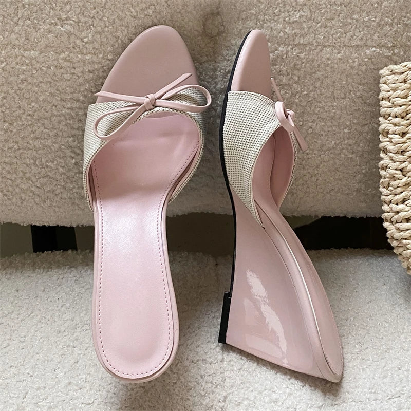Side view of pink bow wedge mules