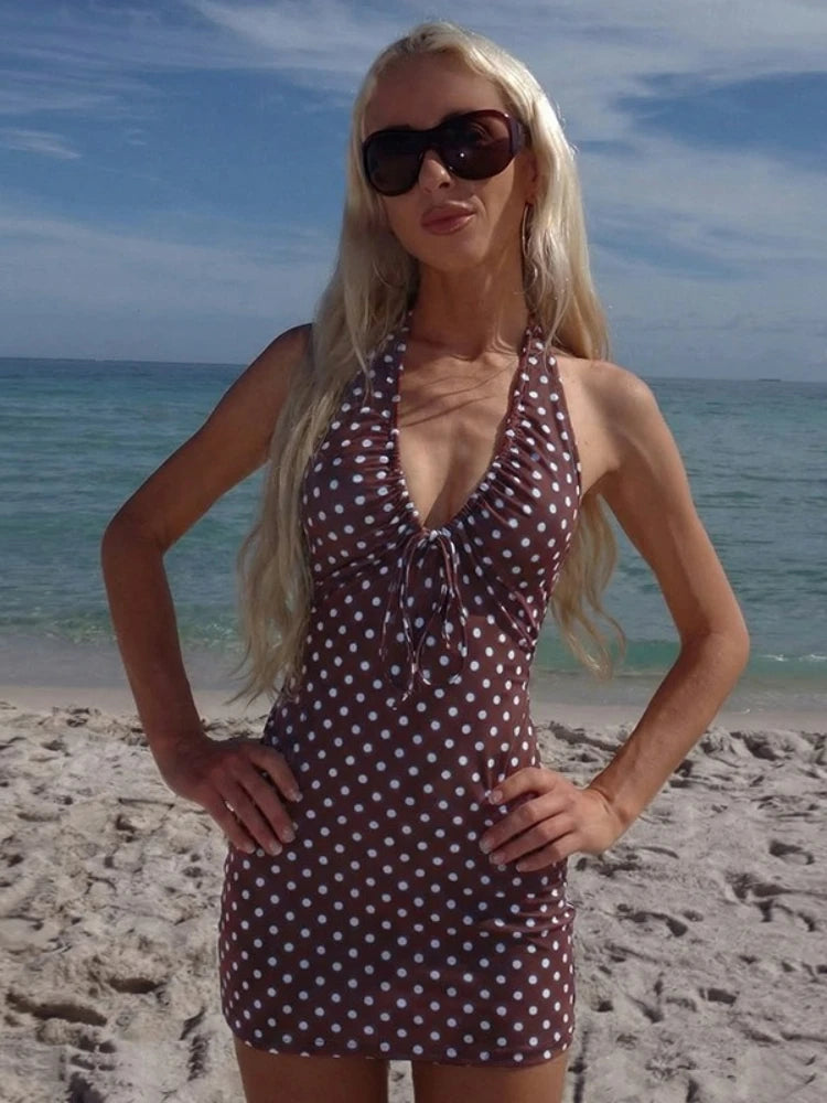Woman in a polka dot dress and sunglasses on a beach