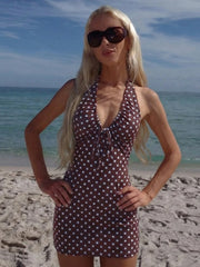 Woman in a polka dot dress and sunglasses on a beach
