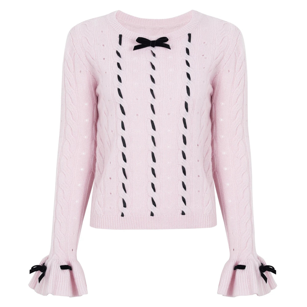 Pink cable knit sweater with black velvet bow embellishments