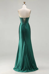 Green evening gown on a mannequin against a white background