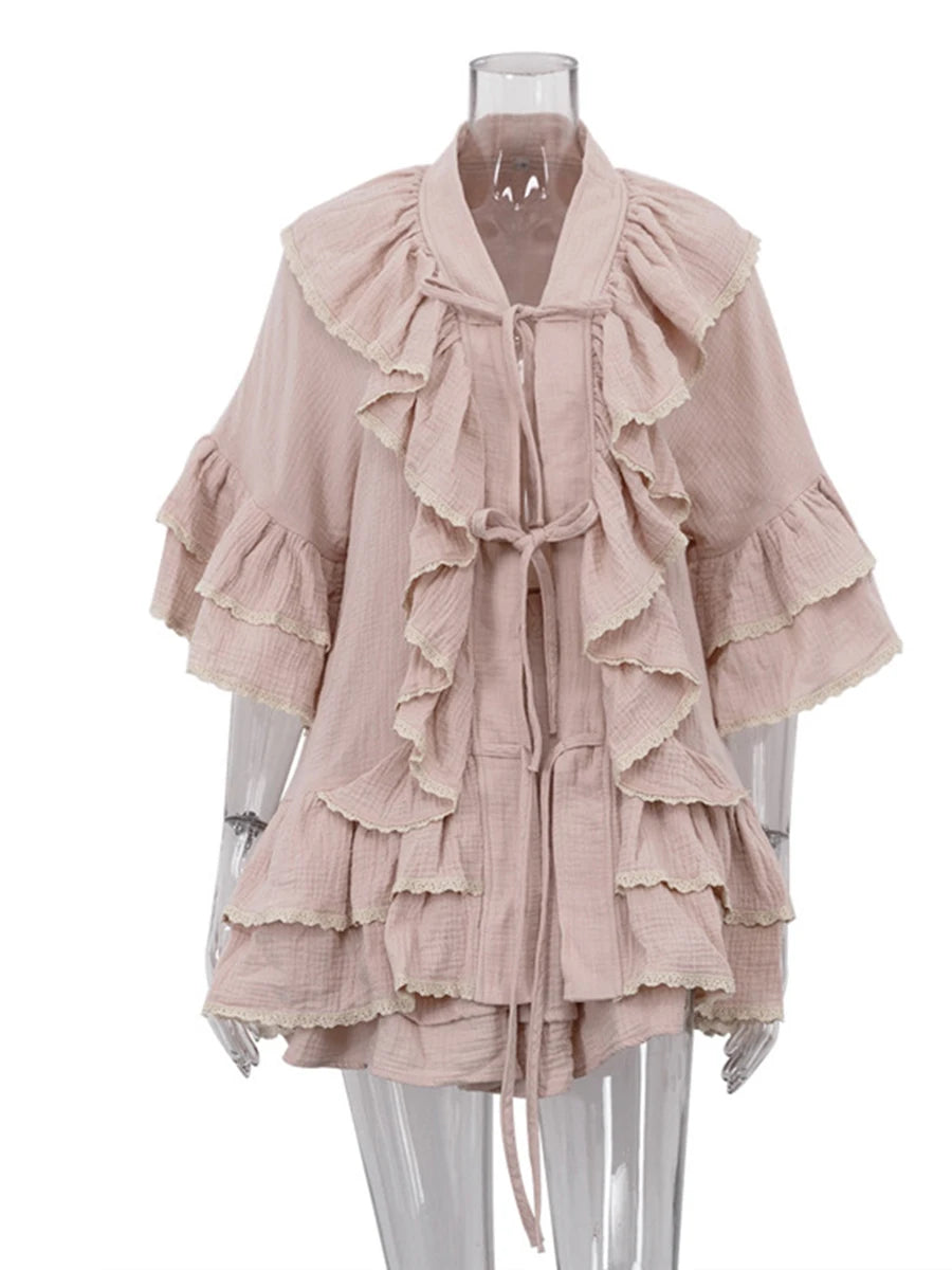 Mannequin displaying a pink ruffled V-neck top with flared sleeves and lace trim, and a ruffled mini skirt.