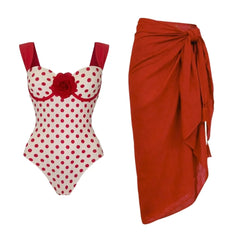 Polka dot bikini and red sarong laid flat